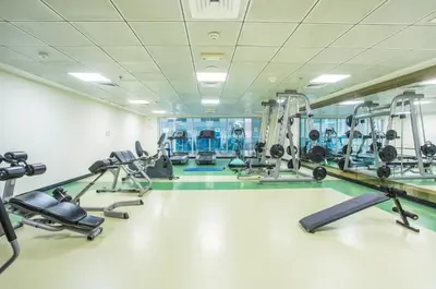a gym with several treadmills and cardio machines at Metro-Accessible 2BR, Easy Reach to Marina Mall and JBR Beach, Featuring Stunning SZR & City Views, Marina Diamond 2, Dubai Marina by Deluxe Holiday Homes in Dubai