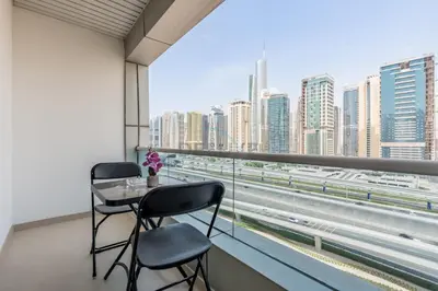 a balcony with a table and chairs and a view of a city at Metro-Accessible 2BR, Easy Reach to Marina Mall and JBR Beach, Featuring Stunning SZR & City Views, Marina Diamond 2, Dubai Marina by Deluxe Holiday Homes in Dubai
