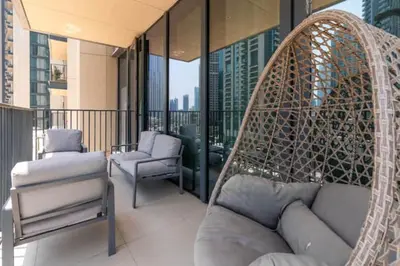 a porch with a couch and chairs on a balcony at Guest Favorite - Modern and Upgraded 2BR Heart of Downtown in Dubai