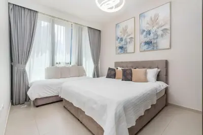 two beds in a bedroom with white walls and windows at Guest Favorite - Modern and Upgraded 2BR Heart of Downtown in Dubai