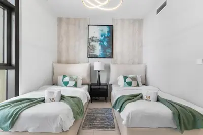 a bedroom with two beds with green and white pillows at Guest Favorite - Luxury 2BR with Full Burj Khalifa View Downtown in Dubai