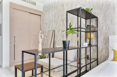 a black desk with a white chair in a room at Sunny Studio with Pool, Near Silicon Central Mall in Dubai