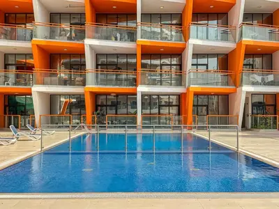 an apartment building with a swimming pool in front of it at Sunny Studio with Pool, Near Silicon Central Mall in Dubai