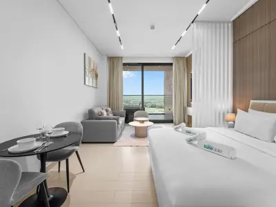 a living room with a large bed and a table at Mesmerizing Canal View Studio in Trillionaire in Dubai