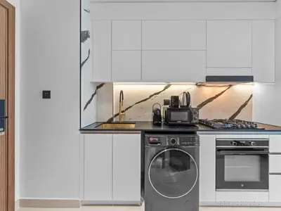 a kitchen with a stove and a washing machine at Mesmerizing Canal View Studio in Trillionaire in Dubai
