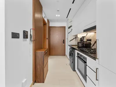 a kitchen with a stove top oven next to a hallway at Mesmerizing Canal View Studio in Trillionaire in Dubai