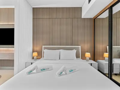 a bedroom with a large white bed with two lamps at Mesmerizing Canal View Studio in Trillionaire in Dubai