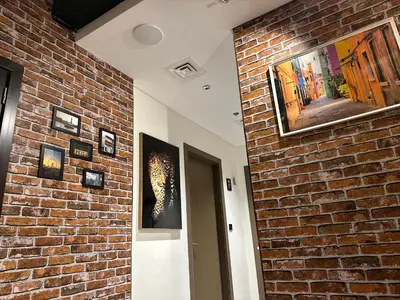 a room with a brick wall with paintings on it at Luxury Hostel Bedspace in Downtown Near Emirates Towers Metro in Dubai