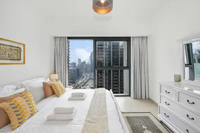 a living room with a white couch and a large window at Stylish 2BR Downtown Dubai in Dubai