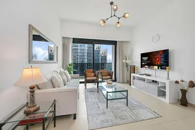 a living room with a couch and a tv at Stylish 2BR Downtown Dubai in Dubai
