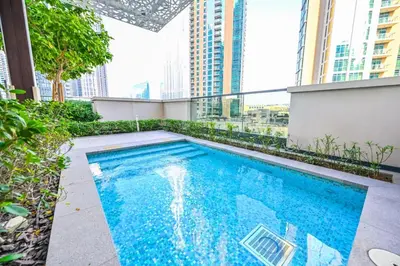 a swimming pool on top of a building with tall buildings at Stylish 2BR Downtown Dubai in Dubai