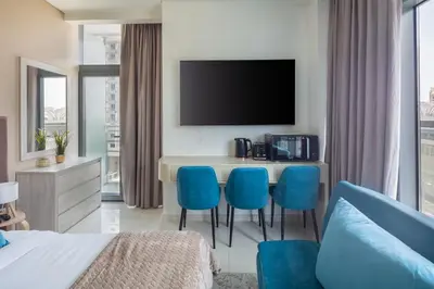 a hotel room with a bed and a table and chairs at Beachfront Studio at West Beach in Dubai