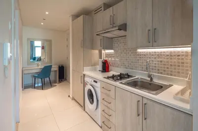 a kitchen with a sink and a washing machine at Beachfront Studio at West Beach in Dubai