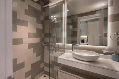a bathroom with a sink and a glass shower at Beachfront Studio at West Beach in Dubai