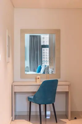 a blue chair sitting in front of a mirror at Beachfront Studio at West Beach in Dubai