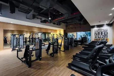a gym with rows of treadmills and machines at Beachfront Studio at West Beach in Dubai