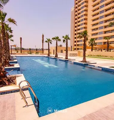 a large swimming pool with palm trees and buildings at Central 1BHK in JVC w Pool near Dubai Sports City in Dubai
