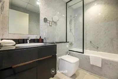 a bathroom with a toilet and a sink and a shower at Central 1BHK in JVC w Pool near Dubai Sports City in Dubai