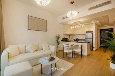 a living room with a couch and a kitchen at Central 1BHK in JVC w Pool near Dubai Sports City in Dubai