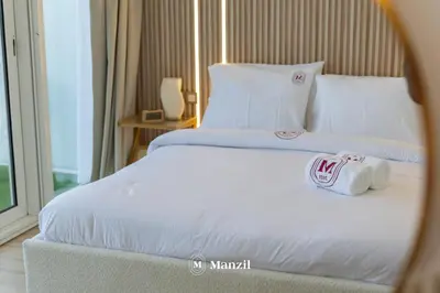 a hotel room with two beds with towels on them at Central 1BHK in JVC w Pool near Dubai Sports City in Dubai