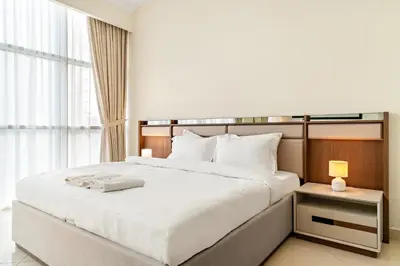 a bedroom with a large white bed and a window at FIRST CLASS 1BR Stylish Vibe in Dubai