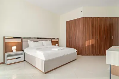 a bedroom with a large bed and wooden cabinets at FIRST CLASS 1BR Stylish Vibe in Dubai