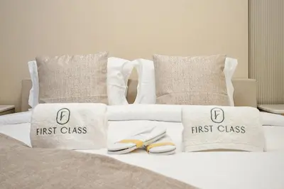 a white bed with first class pillows and shoes on it at Luxury La Mer 1BR Balcony Sea Views Near City Walk and Mall in Dubai