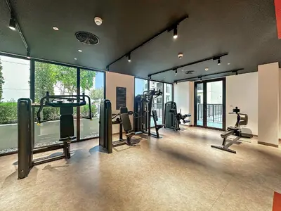 a gym with treadmills and machines in a room with windows at Luxury La Mer 1BR Balcony Sea Views Near City Walk and Mall in Dubai