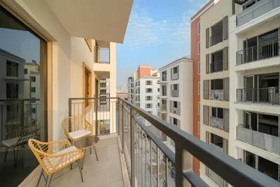 a balcony with chairs and a view of buildings at Luxury La Mer 1BR Balcony Sea Views Near City Walk and Mall in Dubai