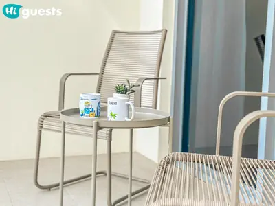 a metal chair with two mugs and a plant on it at HiGuests - Lavish 2BR Apt with Private Beach Access in Dubai
