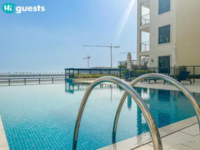 a swimming pool in front of a building at HiGuests - Lavish 2BR Apt with Private Beach Access in Dubai