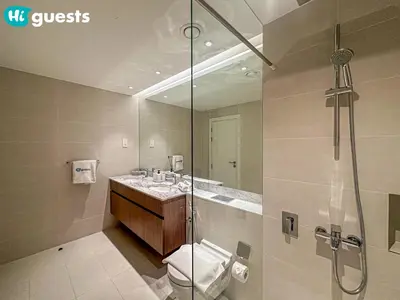 a bathroom with a shower and a toilet and a sink at HiGuests - Lavish 2BR Apt with Private Beach Access in Dubai