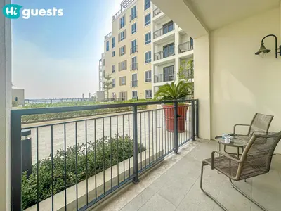 a balcony with two chairs and a table and a building at HiGuests - Lavish 2BR Apt with Private Beach Access in Dubai