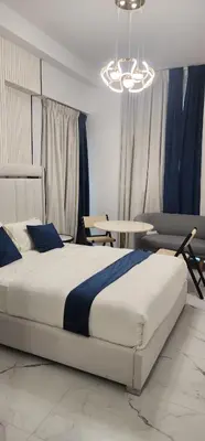 a bedroom with a large bed and a table at Opalz by danube science park in Dubai