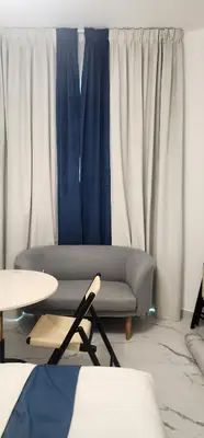 a living room with a couch and blue and white curtains at Opalz by danube science park in Dubai