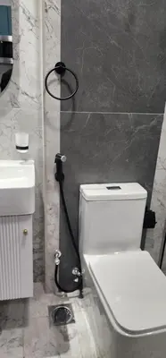 a bathroom with a white toilet and a sink at Opalz by danube science park in Dubai