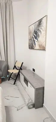 a living room with a table and a chair at Opalz by danube science park in Dubai