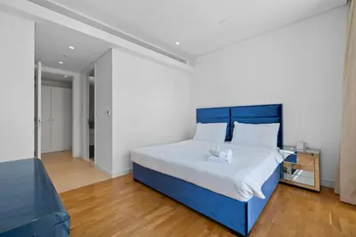 a bed with a blue headboard in a room at Bluewater Residence 6- Spacious Outlet in Dubai