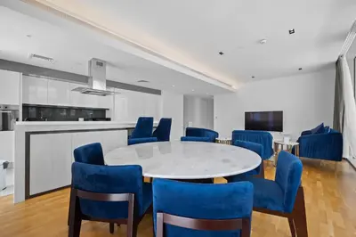 a dining room with a white table and blue chairs at Bluewater Residence 6- Spacious Outlet in Dubai