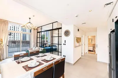 a dining room and living room with a large window at Escape 24 Lux 2BR Collective Dubai Hills in Dubai