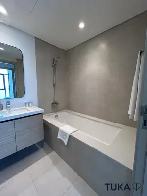 a white bathroom with a tub and a sink at Canal View - 2-BHK - Creek Harbour - Central - Lux in Dubai