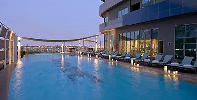 a large swimming pool on the side of a building at Conveniently Located Minutes from Dubai Hills Mall, Park, Golf Club, and Essential City Landmarks 1BR with Premium Facilities, Damac Hills Golf Vita A, Damac Hills 1 by Deluxe Holiday Homes in Dubai