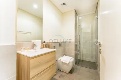 a bathroom with a toilet and a sink and a shower at Conveniently Located Minutes from Dubai Hills Mall, Park, Golf Club, and Essential City Landmarks 1BR with Premium Facilities, Damac Hills Golf Vita A, Damac Hills 1 by Deluxe Holiday Homes in Dubai