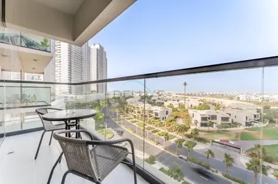 a balcony with a table and chairs and a view of a city at Conveniently Located Minutes from Dubai Hills Mall, Park, Golf Club, and Essential City Landmarks 1BR with Premium Facilities, Damac Hills Golf Vita A, Damac Hills 1 by Deluxe Holiday Homes in Dubai
