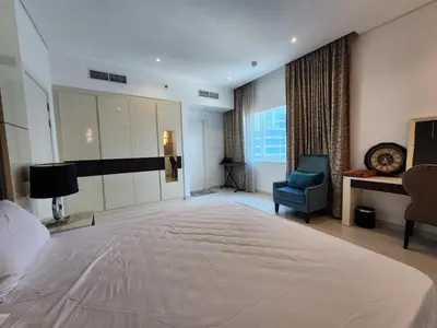 a large bedroom with a large bed and a chair at Stylish Suites 1 Br Business Bay in Dubai