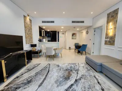 a living room with a couch and a dining room at Stylish Suites 1 Br Business Bay in Dubai