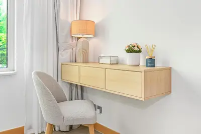 a desk with a chair and a lamp on a wall at Elegant Private Room at The Palm with Beach & Pool Access in Dubai