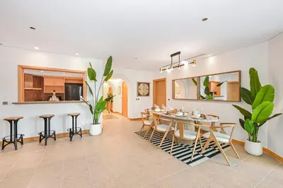 a dining room with a table and some plants at Elegant Private Room at The Palm with Beach & Pool Access in Dubai