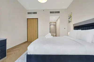 a bedroom with a large white bed and a television at 1 Residences High-Floor Apt with City View, Al Kifaf in Dubai