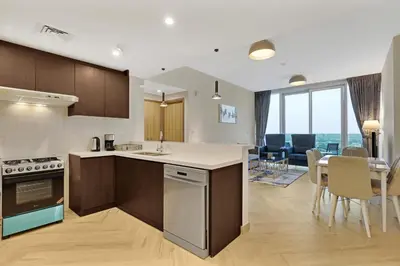 a kitchen and living room with a table and chairs at 1 Residences High-Floor Apt with City View, Al Kifaf in Dubai